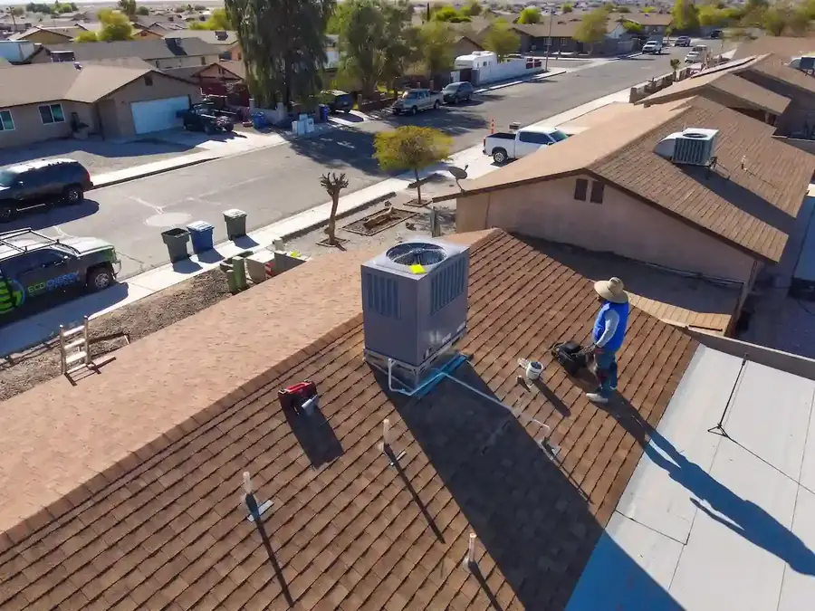 EcoEnergy Solutions technician installing a packaged rooftop AC unit on a Yuma, AZ home