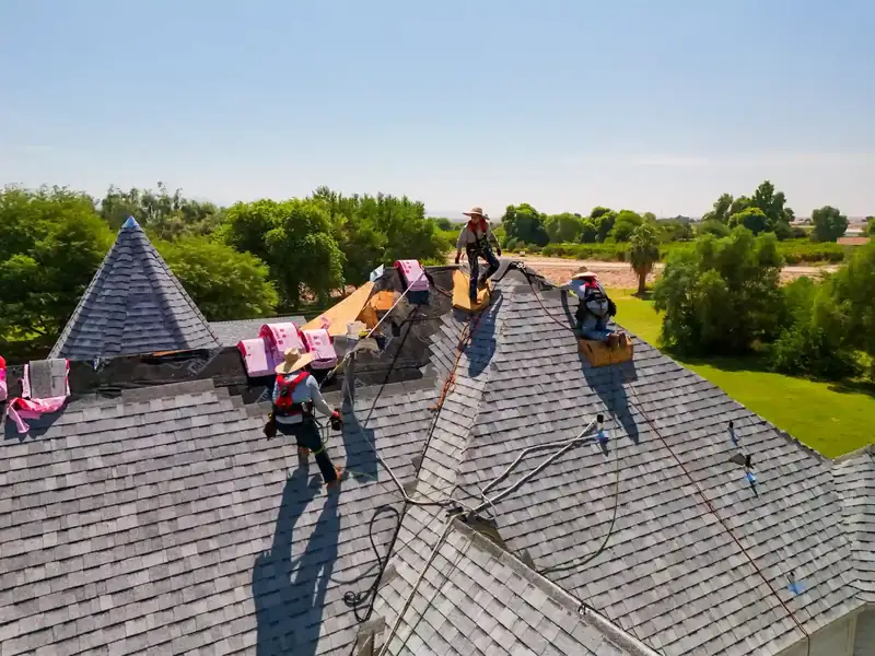 Roofing crew installing shingles on a residential roof in Yuma County