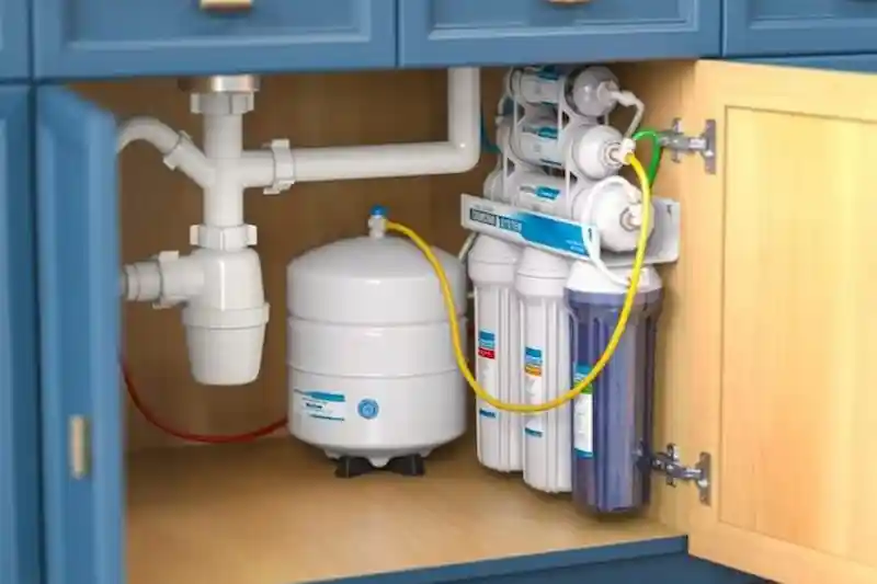 Under-sink reverse osmosis water filtration system installed inside a kitchen cabinet