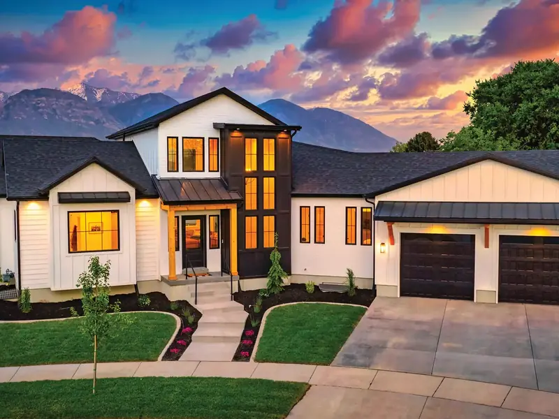 Two-story Yuma home at dusk with its windows lit from inside