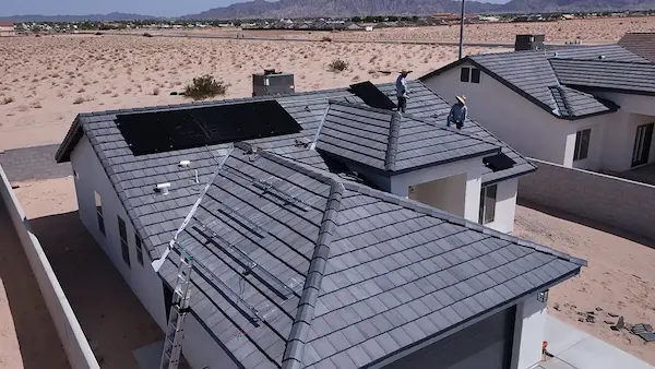 Blue solar panels on a gray shingle roof