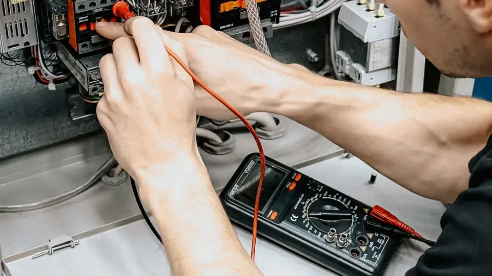 Technician Testing an EV Charging Circuit With a Multimeter