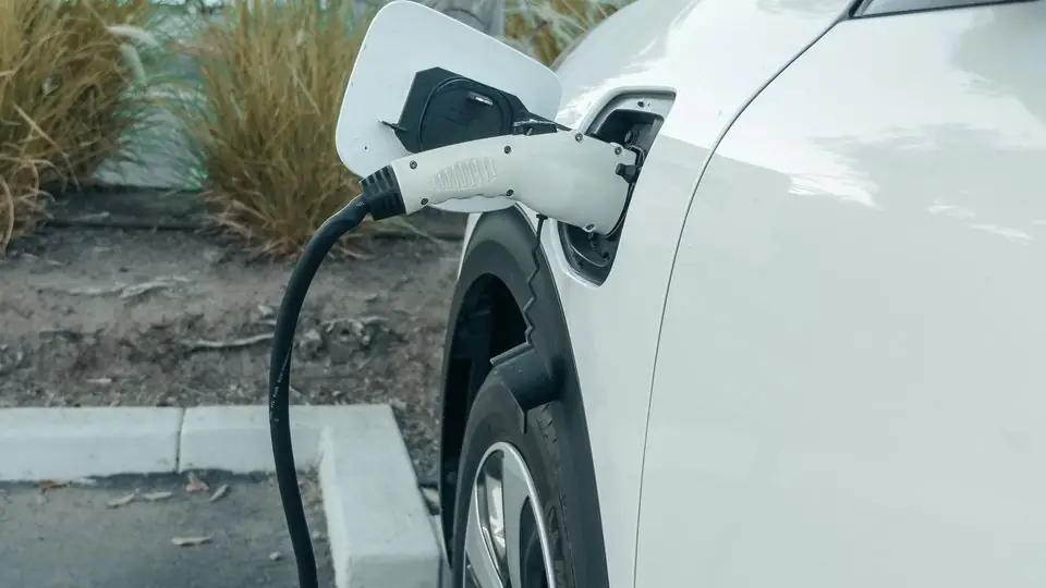 White Electric Vehicle Plugged Into a Curbside Charger