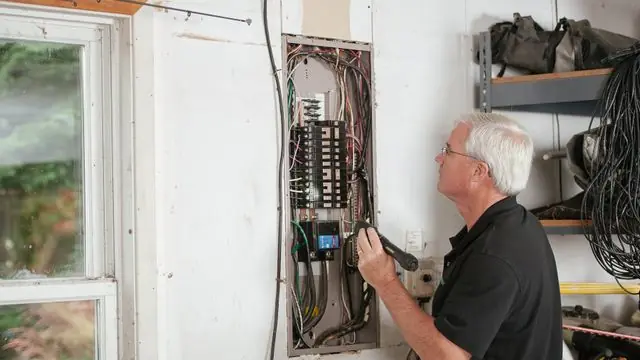 Electrician Assessing an Electrical Panel Load Before an EV Charger Installation