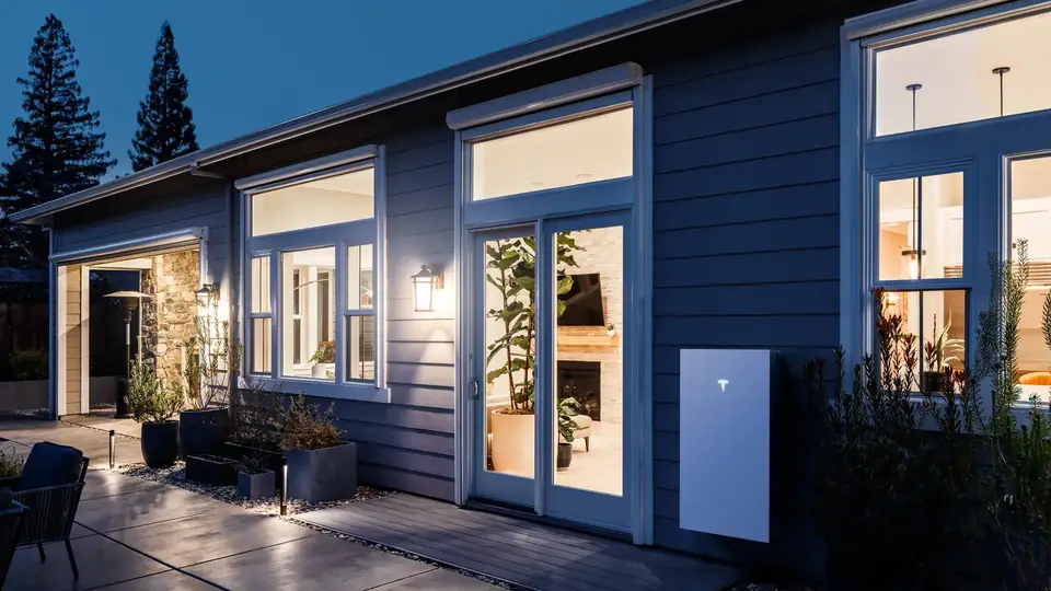 Tesla Powerwall Installed on a Home Exterior at Dusk